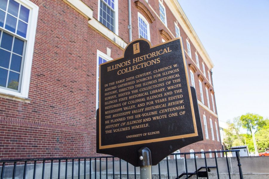 A historical marker displaying information about Illinois Historical Collections sits next to the Main Library. The University's Libraries are home to numerous historic collections and documents.