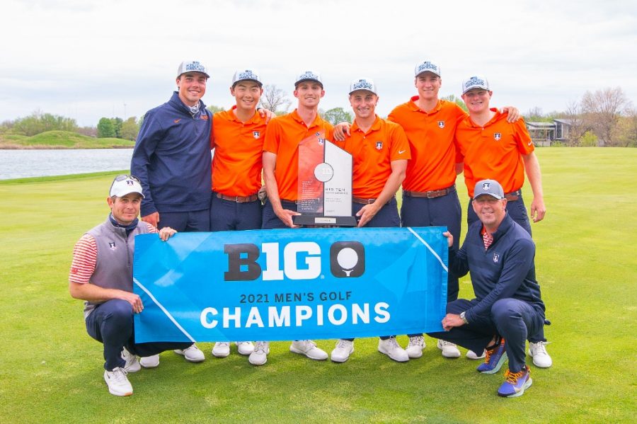 The men’s golf team poses with a banner and trophy after winning the Big Ten Golf Tournament May 2.