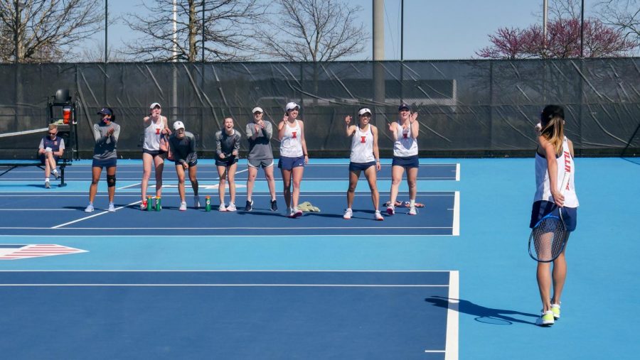 Senior+Emilee+Duong+celebrates+winning+a+point+with+her+teammates+cheering+her+on+from+a+neighboring+court+at+the+match+against+Michigan+State+April+9.+The+team+capped+off+the+year+with+a+9-9+record.