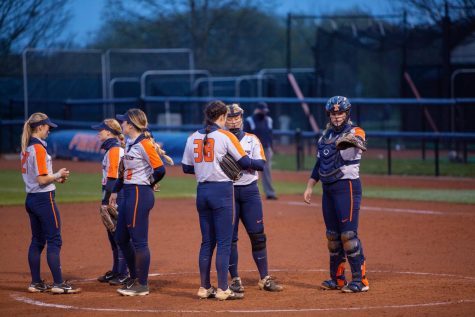 The Illinois softball team meets on the mound to discuss pitching strategies against Indiana April 23. This upcoming weekend, the Illini will face Iowa in its last four-game series of the regular season. 