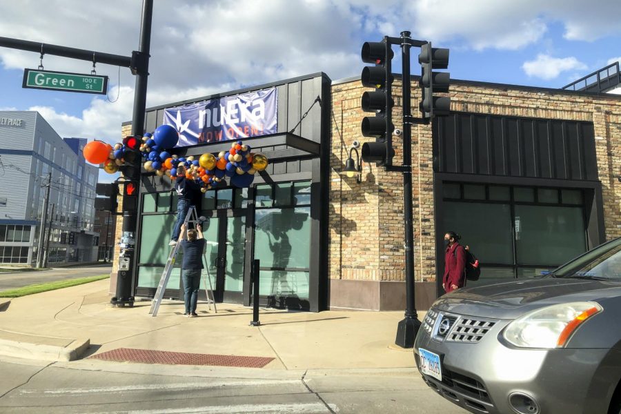 Workers at the NuEra cannabis dispensary hang balloons above the entrance April 15. The adult-use dispensary opened on Green Street last month.