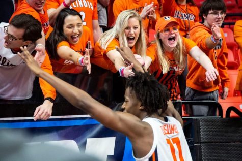 Students in the Orange Krush section of the State Farm Center lean over a railing to high five Ayo Dosunmu after Illinois won against Iowa March 8, 2020. Attending sporting events is the ideal way for passionate Illinois fans to experience campus. 