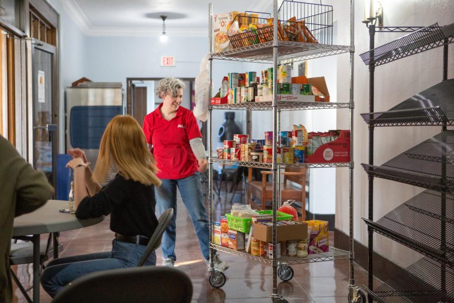 Food Pantry Director Dawn Longfellow wheels a rack of food at a food pantry in the Champaign area on Feb. 21, 2020. Food banks are looking for student volunteers to help out. 