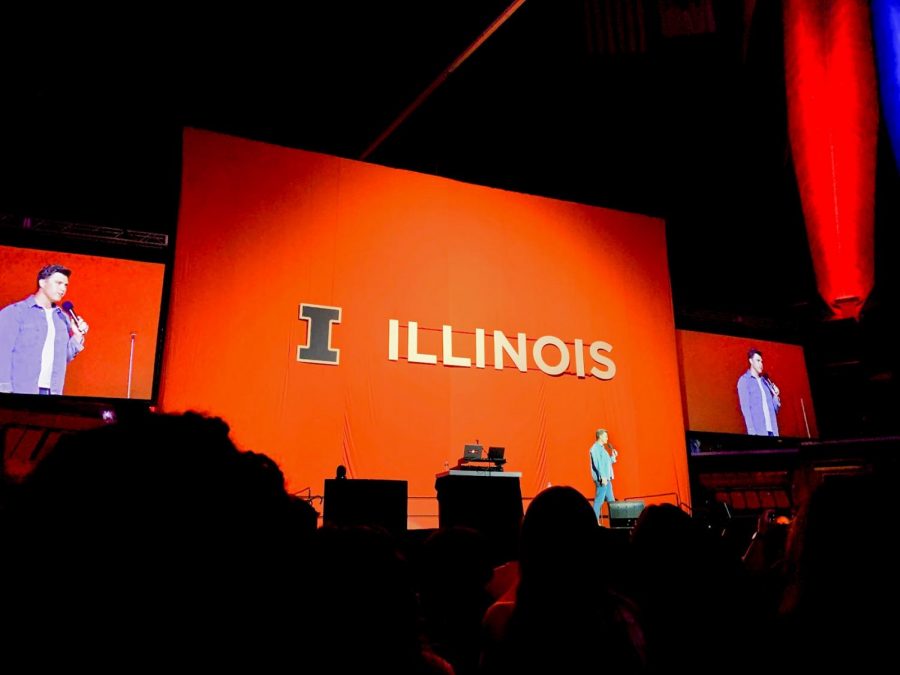 Colin Jost walks across the stage at the State Farm Center. Colin Jost preformed for new and transfer students as a nice welcome to campus.
