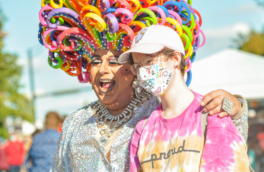 A drag queen poses for a photo with a parade goer during pride festivities on Saturday in Urbana. Committee members at Uniting Pride of Champaign County have been hard at work setting up this years Pride parade.