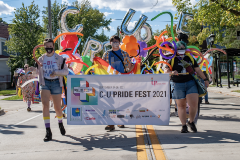 A group of people hold up a banner folowed by others with baloons at the start of the C-U Pride Parade on Saturday in Urbana. 