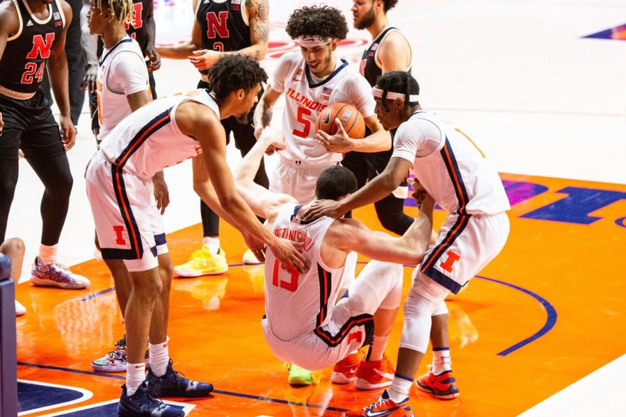 Jacob Grandison, Andre Curbelo, and Trent Frazier help fellow teammate Giorgi Bezhanishvili up during the game against Nebraska Feb. 25. Illinois welcomes fans back to State Farm Center tonight for the mens basketball exhibition match against St. Francis. 