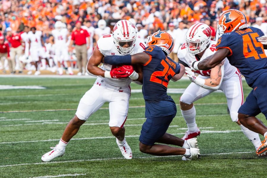 Defensive back Kerby Joseph attempts to block a Wisconsin player during the game Oct. 9. The Daily Illini sports staff makes predictions ahead of the teams game against Penn State this weekend. 