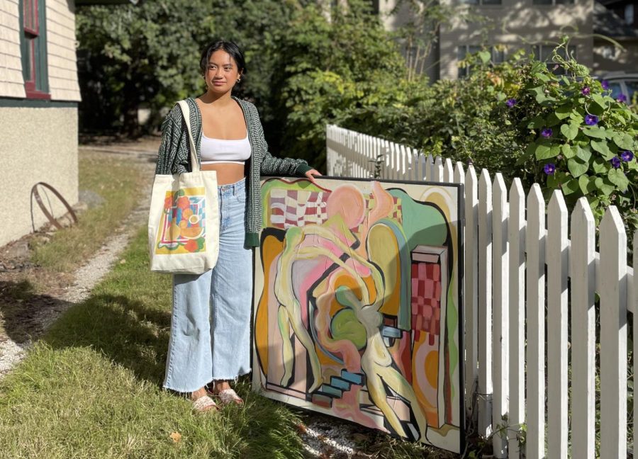 Gianne+Garcia%2C+University+student+and+owner+of+Tidy+Totes%2C+holds+one+of+her+handmade+tote+bags+while+standing+next+to+a+painting+she+created.+Garcia+is+thankful+for+the+amount+of+support+shes+received+for+her+small+business.