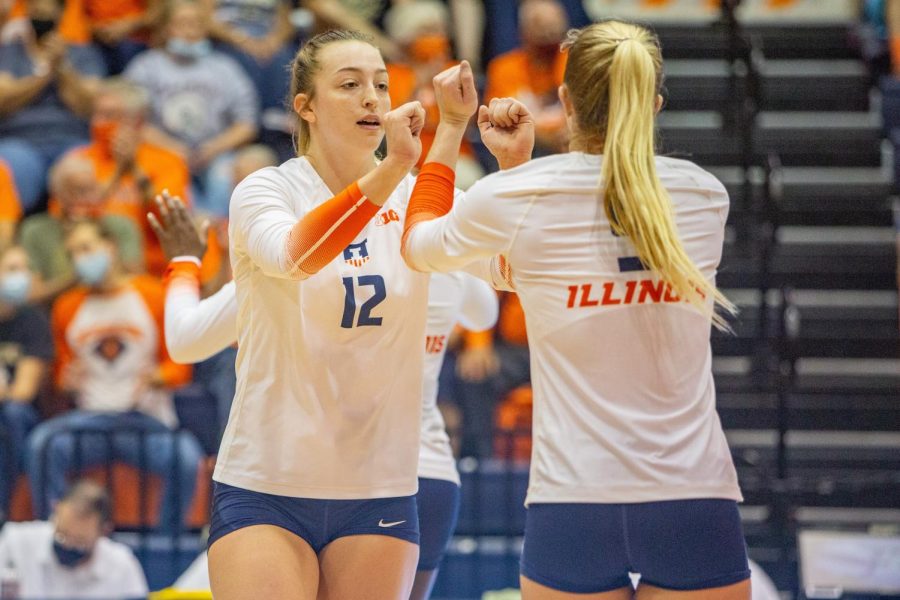Outside hitter Raina Terry (12) and Diana Brown hype each other up during a set against Purdue on Oct 6. The Illini hope to keep up their momentum from their victory against Penn State for their match against Nebraska. 