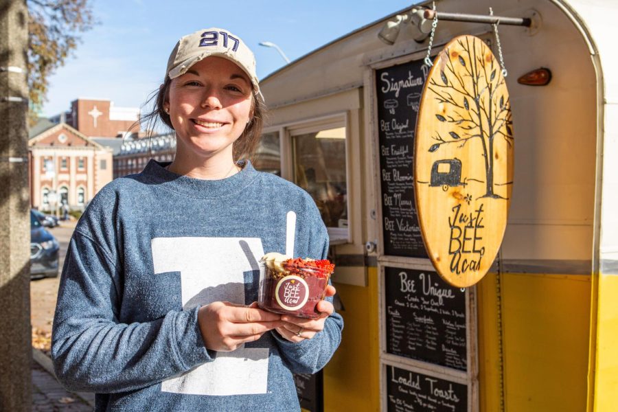 Emma Curcuru, a University alumna, holds a Bee Sassy acai bowl outside of the Just Be Acai camper on Friday morning. Curcuru founded the business and has been extremely successful on campus with help from her family.