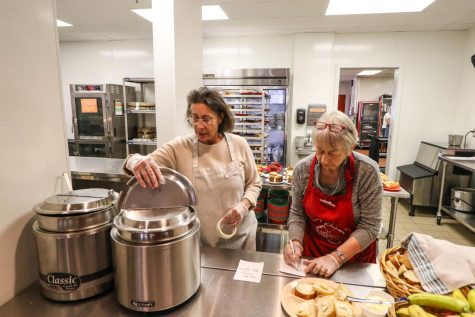 Two workers prep food at the Daily Bread Soup Kitchen on Oct. 17, 2018. Despite Covid-19 regulations, the kitchen continues to operate outside the dining room. 