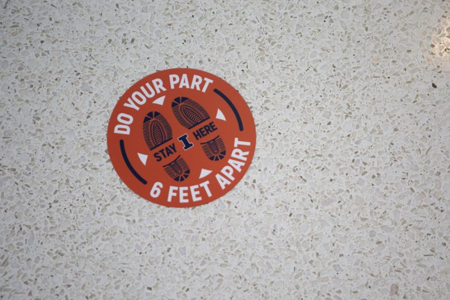 A sticker saying Do Your Part 6 Feet Apart is placed on the ground at the Covid-19 testing center at State Farm Center Oct. 9, 2020. Survivors of Covid-19 report that they still have issues with their sense of smell and taste.