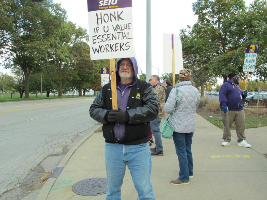 A man protests the University’s lack of response to their complaints about pay discrepancies and lack of respect for service workers on Wednesday. The local chapter of the Service Employees International Union will not rest until their needs are met.