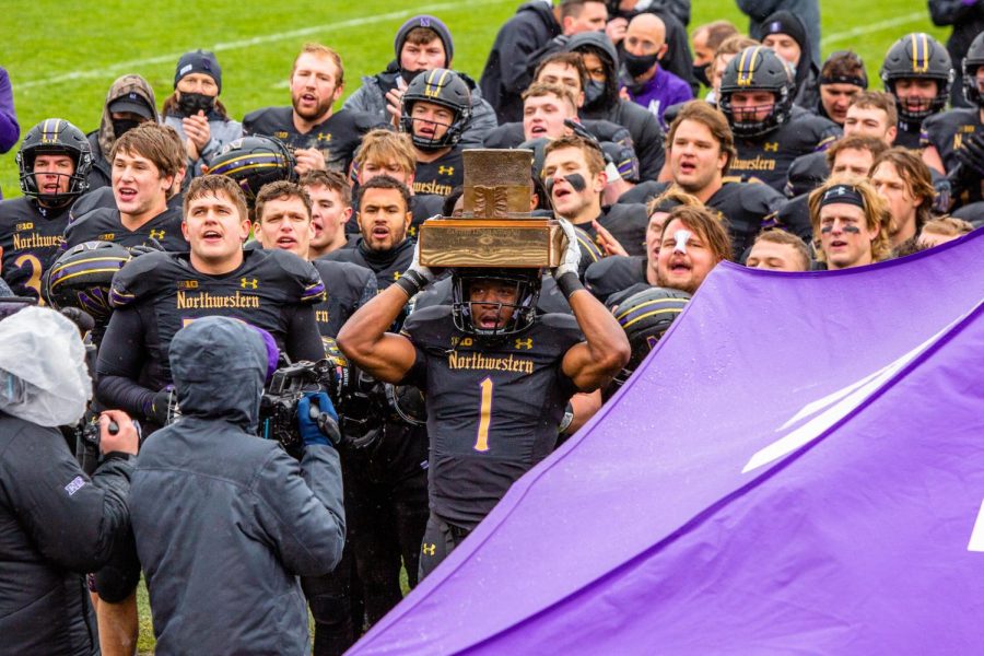 Northwestern celebrates after winning the Land of Lincoln trophy against Illinois after last years game at Ryan Field on Nov. 27, 2020. The Daily Illini sports staff makes predictions on how the Illinois Northwestern game will play out today.