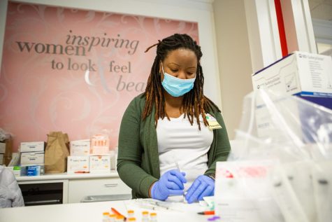 Mariah, Carle Pharmacist, fills pediatric doses of the Pfizer vaccine at the Carle Health vaccination pop-up on Nov. 6. The university urges students to get their booster shots before the spring semester. 