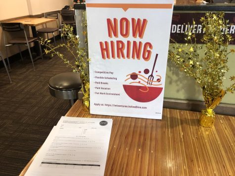 A now hiring sign sits on a table at Noodles & Company. College seniors say it is difficult to get a job despite the labor shortage.