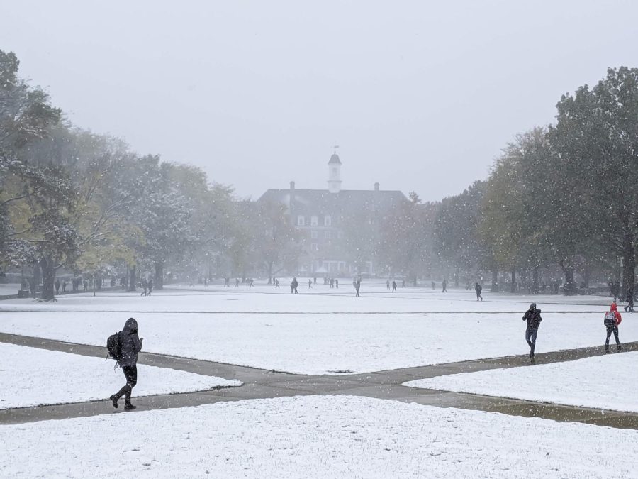 Students walk on the Main Quad as snow falls on Oct. 31, 2019. Students plan for post-finals week, and some decide to stay on campus over winter break. 