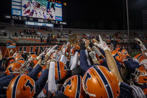 The Illinois football team celebrates with the Land of Lincoln Trophy after winning the game against Northwestern on Nov. 27. The Daily Illini sports staff gives out their end of season football grades.