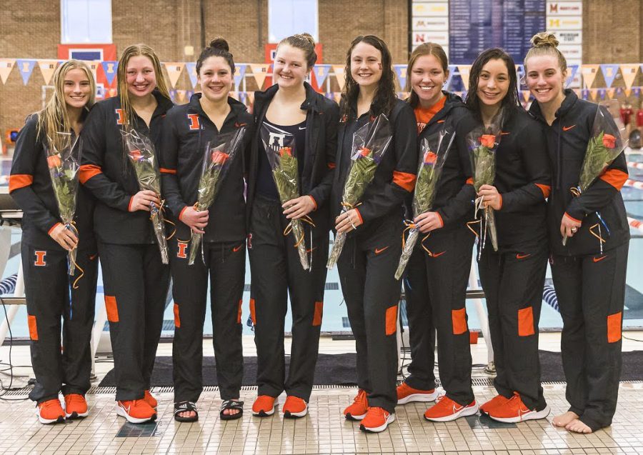 Illinois swim and dive seniors pose for a photo with flowers in hand during senior day at the ARC on Saturday. Alongside team effort, the seniors’ contributions lead to a successful season. 
