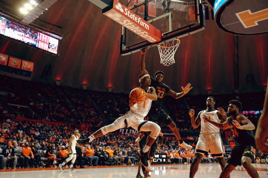 Trent Frazier jumps with the ball beneath the basket during Illinois mens basketballs game against Maryland on Thursday at State Farm Center.