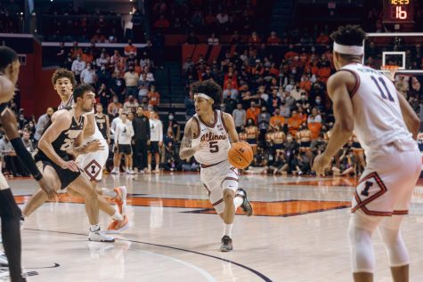 Andre Curbelo dribbles the ball and drives to the paint during Illinois game against Purdue at State Farm Center on Monday. Curbelo made a surprise return, scoring 20 points in the Illinis 96-88 loss.