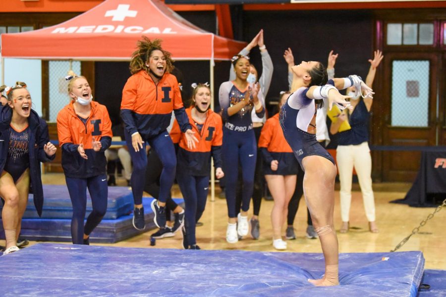 Junior+Mia+Takekawa+and+rest+of+the+team+celebrate+as+Takekawa+sticks+her+landing+during+her+event+on+bars+against+Rutgers+on+Friday.+The+Illini+won+against+the+Scarlet+Knights+196.650-195.475.