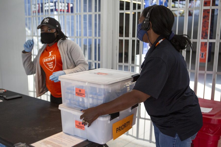 SHIELD testing workers take away a container filled with Covid-19 tests at State Farm Center on Oct. 9, 2020. CUPHD plans to work with SHIELD and other services in regards to contact tracing and the new statewide policy. 