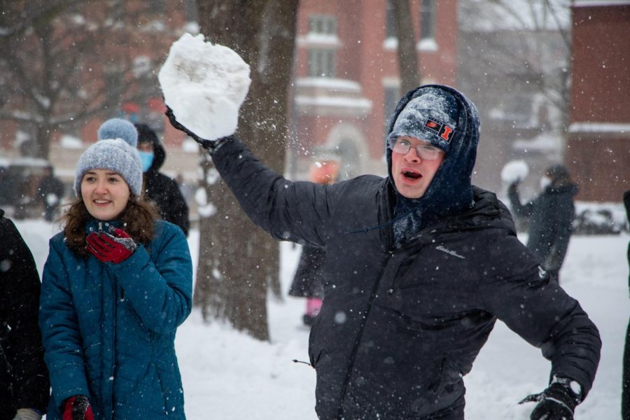 A student throws a big snow chunk during the snowball fight on the quad. 