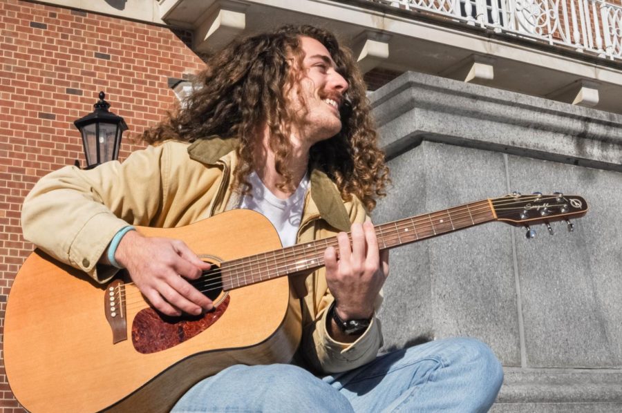 University alumnus Garrett Frank plays the guitar outside of the Illini Union on Saturday. Frank recently joined the band Kangaroo Court last fall. 
