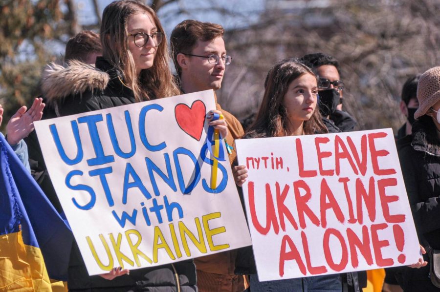 People hold signs in support of Ukraine during the rally held at Alma Mater on Sunday. The rally was held by the Ukrainian Student Association with around 250 attendees. 