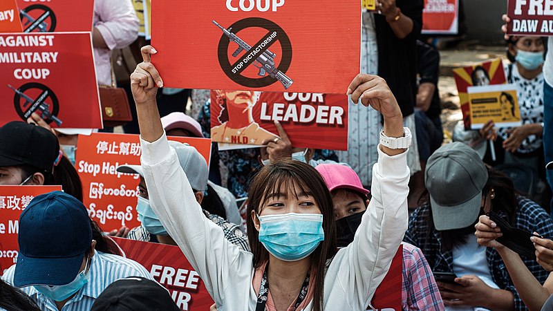 Protester holds a sign against the military coup in Myanmar on Feb. 14, 2021. Senior columnist Eddie Ryan discusses the anniversary of Myanmars coup being overshadowed by the Ukraine situation. 
