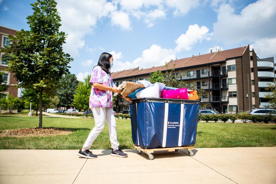 Natalie Romanes, sophomore in LAS, pulls a cart of belongings into Wassaja Hall on Aug. 20. 
