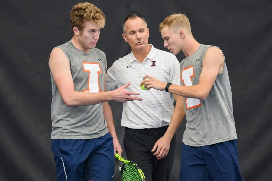 Illinois mens tennis head coach Brad Dancer talks with graduate student Alex Brown and Freshman Gabrielius Guzauskas during their doubles match against Baylor on March 4. Dancer goes more in depth when it comes to the teams improvement during the season. 