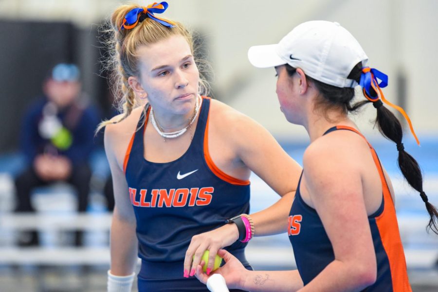 Freshman Megan Heuser receives the ball from doubles partner, sophomore Kate Duong, during their doubles match against Rutgers on Sunday. Both Heuser and Duong won their doubles and individual singles match against the Scarlet Knights, and the Illini overall swept the team 7-0. 