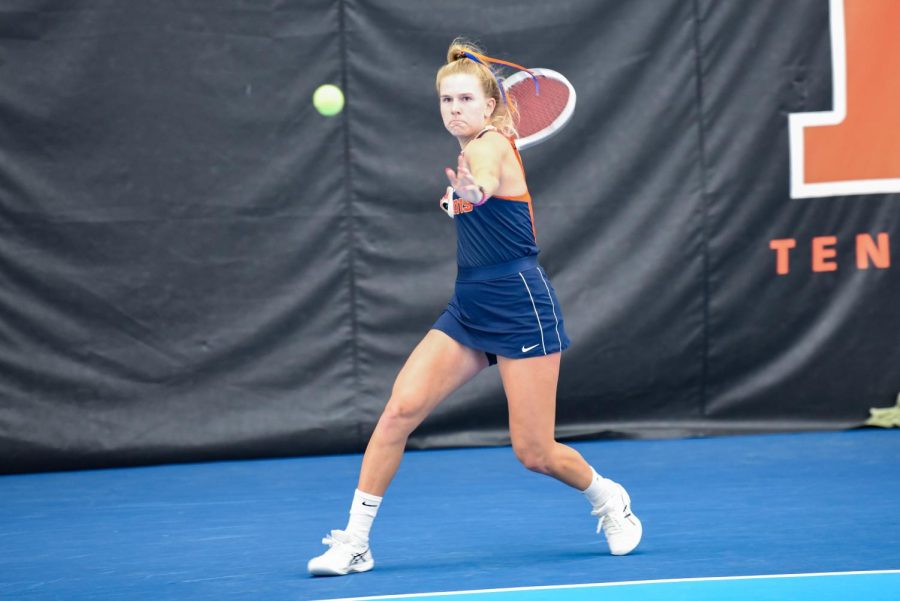 Freshman Megan Heuser powers up her swing during her singles match against Rutgers on March 27. Illinois took down Iowa to advance to second round of Big Ten tournament.