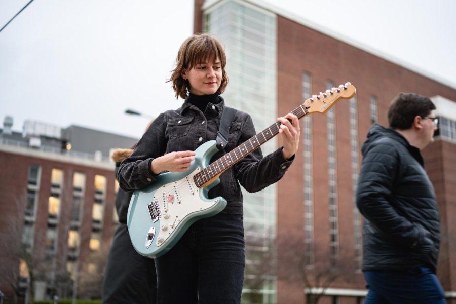 Kamila Glowacki plays her guitar by Oregon Street and Goodwin Avenue on April 5.  Glowacki, founder of the band Nectar and alum from the University, provides insight to her positive relationship with the C-U area, which often inspires the creation of her songs. 

