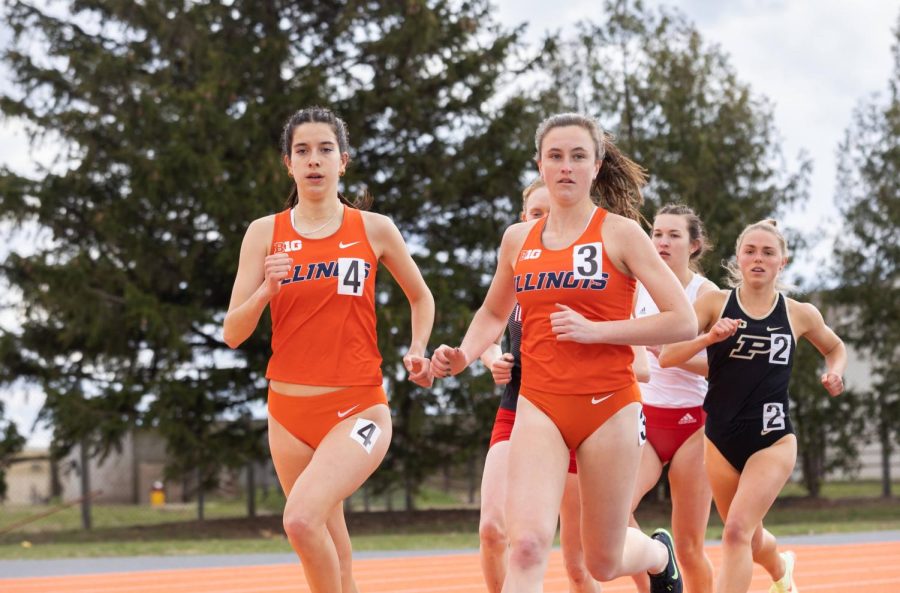 Senior distance runner Emma Milburn runs alongside freshman distance runner Annalyssa Crain during the Illini Classic meet on April 9. The Illini will be hosting an invitational on Friday and Saturday featuring other teams from Illinois State, SIUE and more. 