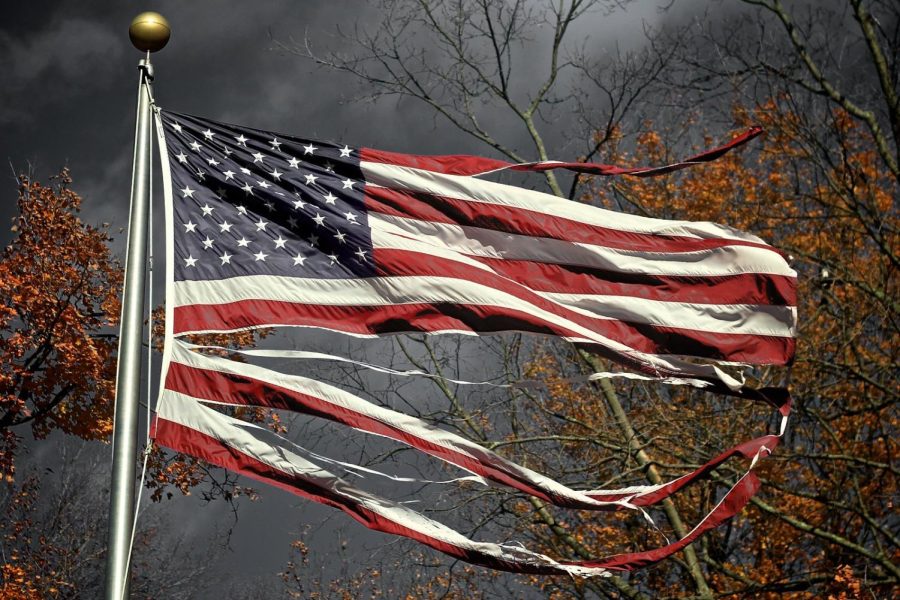 A tattered American flag sways at Wilmington’s Sugar Grove Cemetery on Oct. 28, 2010. Senior Columnist Jude Race suggests that people should work more as a collective in America rather than isolating ourselves from one another. 