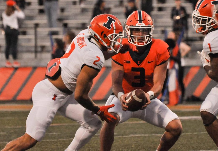 Junior running back Chase Brown receives the ball from senior quarterback Tommy DeVito during the first half of the Spring Orange and Blue Game on Thursday. Brown and sophomore running back Josh McCray ran for a combined 174 yards during the game. 