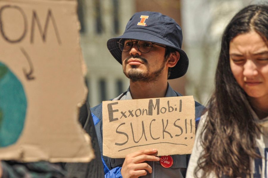 Diego Lopez, freshman in LAS, stands within the crowd holding a sign saying Exxon Mobile Sucks during the Climate Strike on Friday. The strike was organized by SECS and protesters marched throughout campus from the Alma Mater statue to Green Street. 