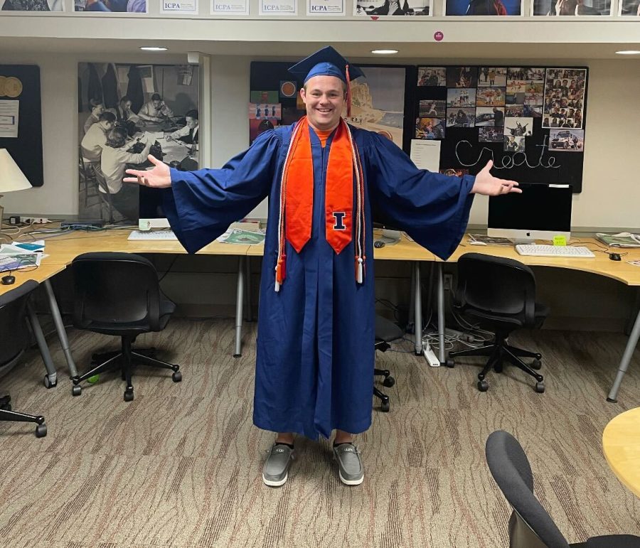Senior columnist Noah Nelson showcases his graduation attire at The Daily Illini office. Noah expresses his gratitude for his time working for the paper. 