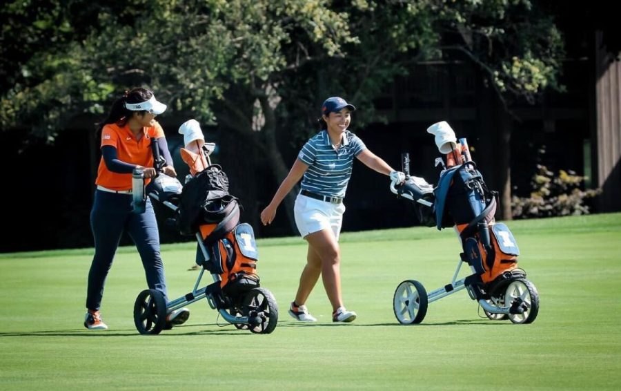 Senior Crystal Wang and sophomore Isabel Sy move their equipment on the course. The Illinois womens golf team has recruited two new players for the upcoming season: Mattie Frick and Anna Ritter. 