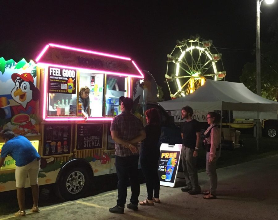 Kona+Ice+employee+taking+orders+for+a+delicious+treat+from+fair+attendees+at+the+Champaign+County+Fair.+Co-owner+of+Kona+Ice+Wes+Hanner+shares+his+excitement+for+the+Champaign+County+Fair+this+year+from+July+22-July+30+and+for+Kone+Ice+to+be+attending+again+in-which+the+snow+cone+truck+has+been+a+vendor+for+7+years+at+the+fair+serving+a+wide+variety+of+snow+cones+for+everyone+to+enjoy.+