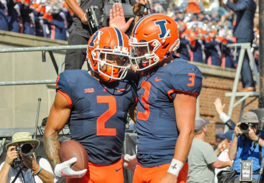 Senior quaterback Tommy DeVito congratulates junior running back Chase Brown on his touchdown during the game against Wyoming on Saturday. 