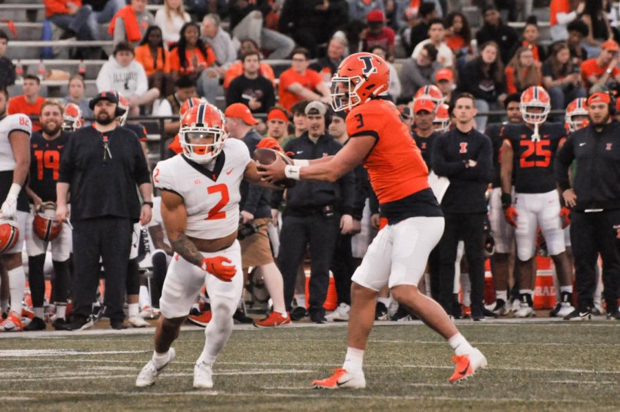Senior quaterback Tommy DeVito (3) passes the ball to junior running back Chase Brown (2) during the Spring Orange and Blue game on April 21. DeVito, who transferred from Syracuse, will be this seasons starting quarterback.  