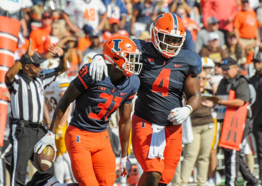 Junior defensive back Devon Witherspoon (31) celebrates with sophomore defensive lineman Johnny Newton (4) during Saturday’s game against Wyoming. The Illini will be back at Memorial Stadium on Saturday to go against Virginia. 