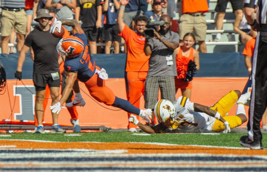 Running back Chase Brown catches the ball while heading towards the end zone during the game against Wyoming on Aug. 27. Mike Barber of the Richmond Times-Dispatch shares his predictions and inputs for the upcoming match this Saturday on the latest Daily Illini Sports Podcast. 