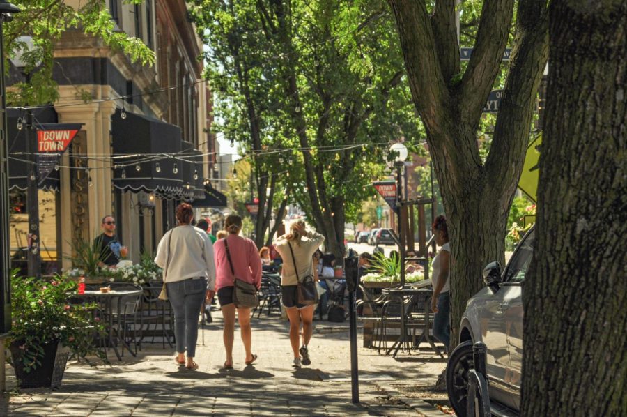 People walk and gather by the local stores and cafes of downtown Champaign on Saturday. The C-U community is always adapting to fit both needs of students and residents. 

