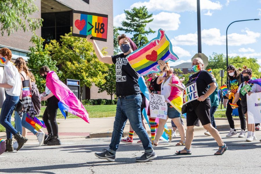 A parade participant holds a sign promoting love over hate at the Uniting Pride C-U Pride Fest on Sept. 25, 2021. This years Pride Fest will feature 17 events that will be happening around the community. 